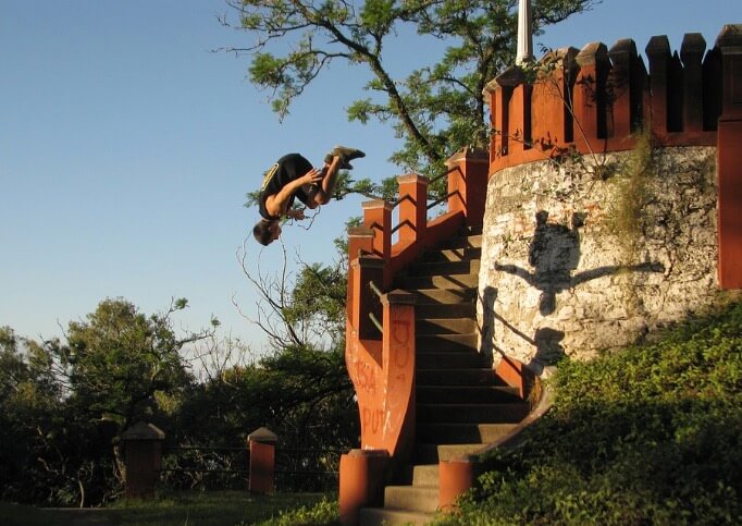 Homem praticando parkour em uma escada.