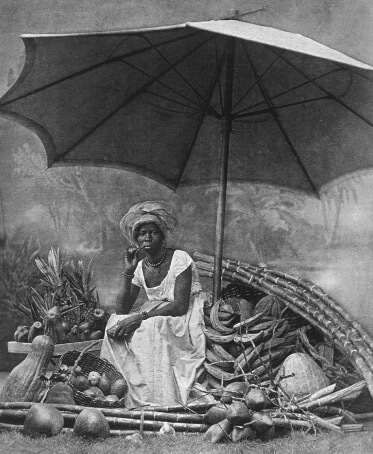 Foto de uma senhora negra vendendo frutas.