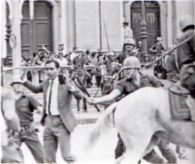 Foto do protesto onde um policial agride um manifestante.