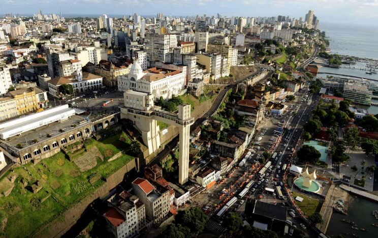 Foto da cidade alta e baixa de Salvador, com o elevador Lacerda ao fundo.