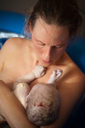 Foto de uma mãe segurando seu bebê recém-nascido.